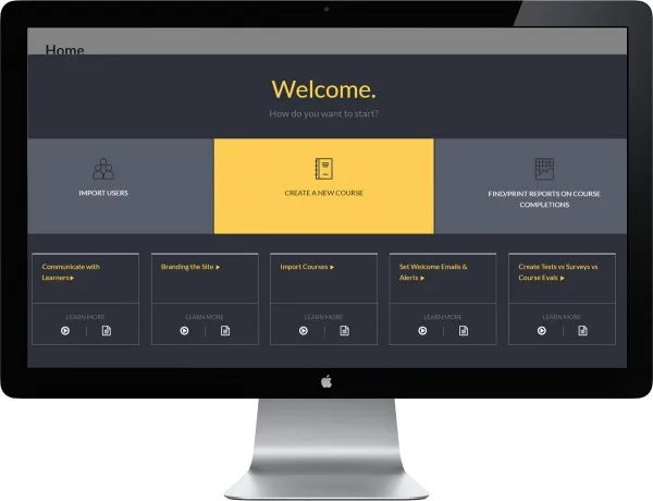 Monitor displays a dark welcome dashboard with a yellow “Create a New Course” panel and gray navigation options.