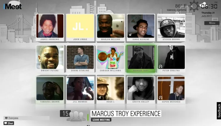 Video-call interface displays fifteen participant tiles, including portraits, names, a grayscale cityscape background, and Marcus Troy’s meeting status.