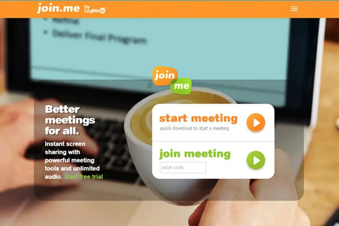 Laptop, coffee cup, and hands appear behind a join.me overlay with orange and green meeting buttons.