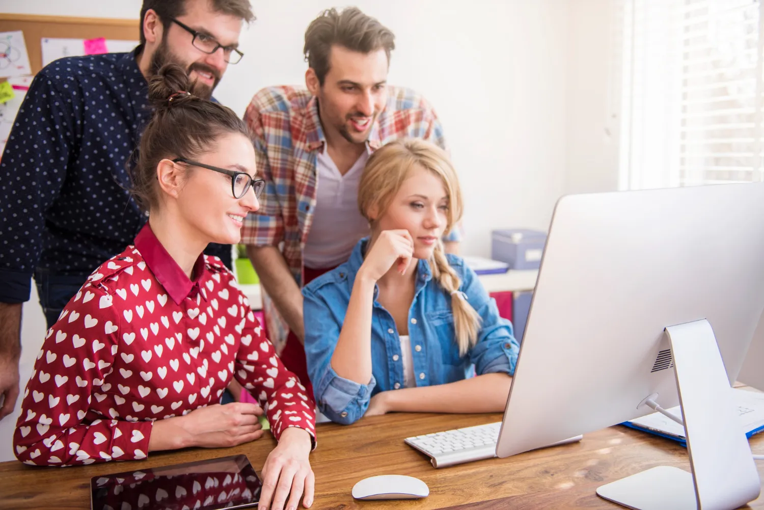 Team collaborating on a computer in a modern workspace.