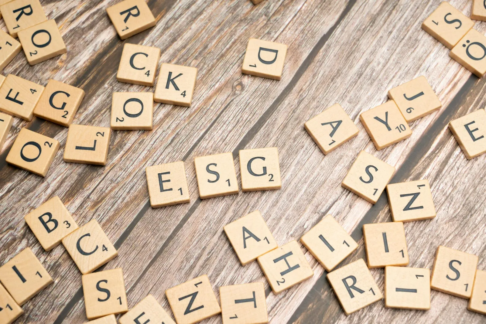 Scrabble letter tiles on wooden background for educational games.