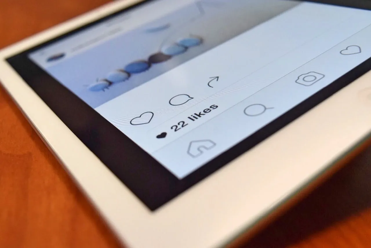 Tablet screen showing a social media post with 22 likes and engagement icons.