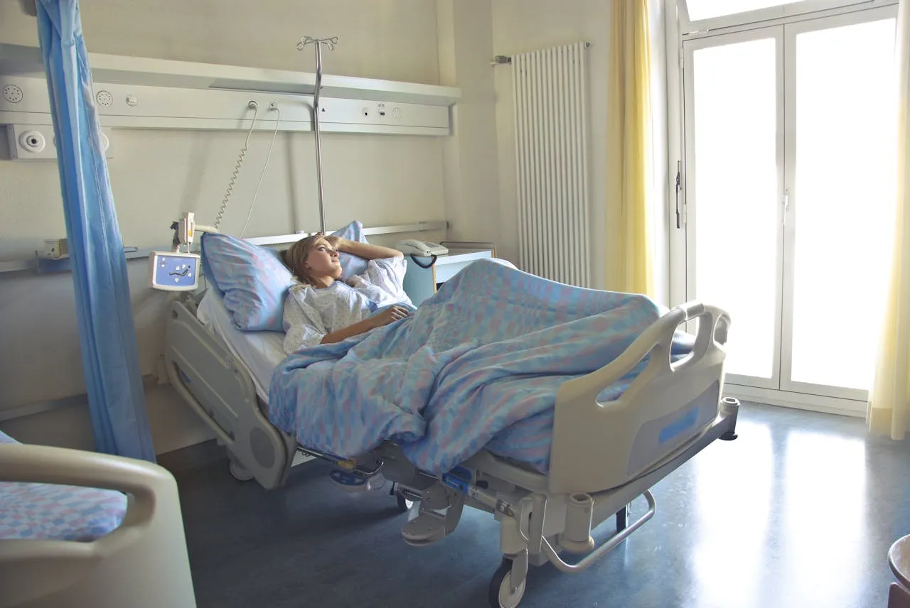 Child patient reclining in hospital bed with medical equipment.