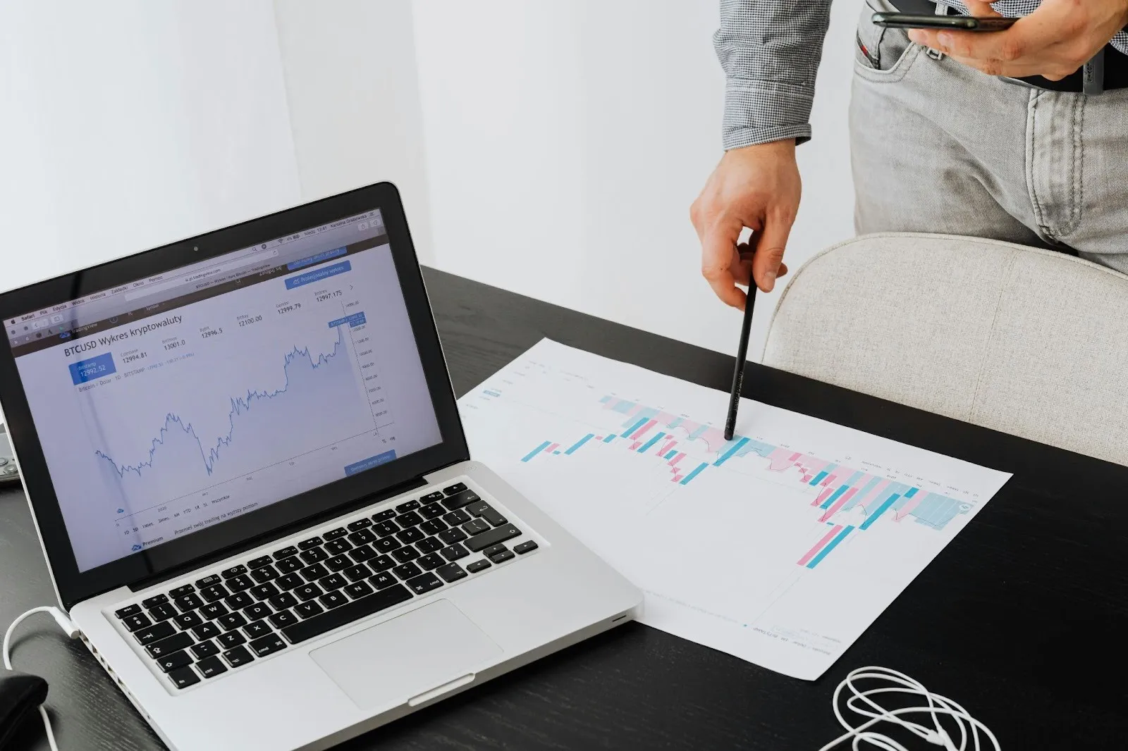 Laptop shows crypto chart with paper for trading data analysis