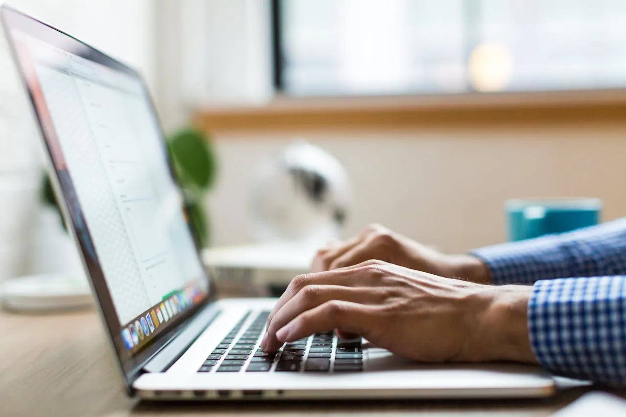 Hands typing on laptop keyboard for work or study