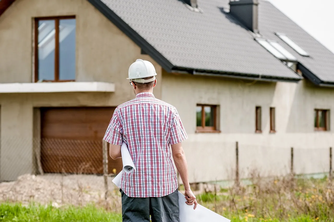 Architect in hard hat viewing house construction site.
