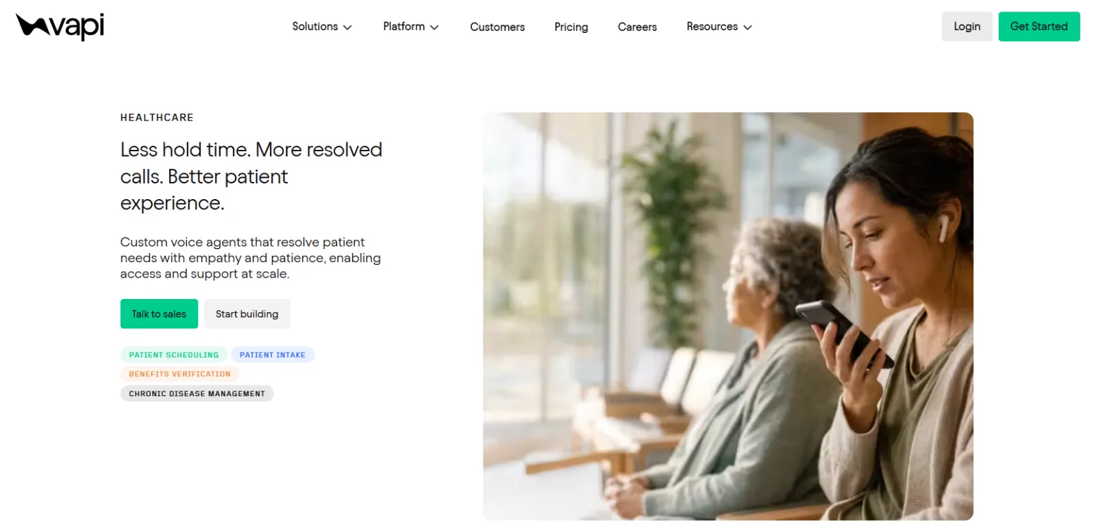 Healthcare webpage shows text and buttons beside a woman holding a smartphone near a seated older woman.